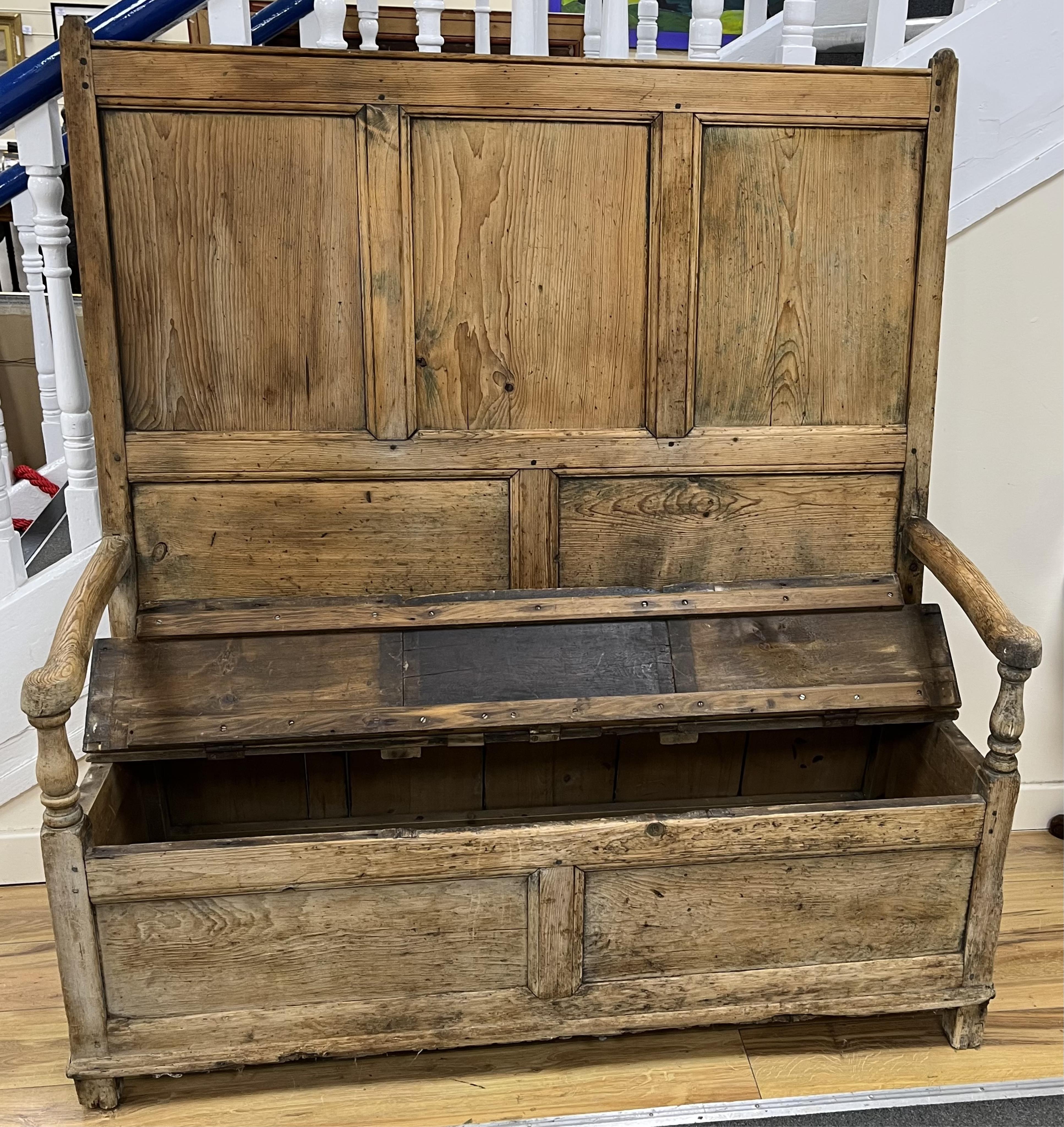 An 18th century panelled pine settle, width 127cm, depth 46cm, height 140cm. Condition - poor to fair